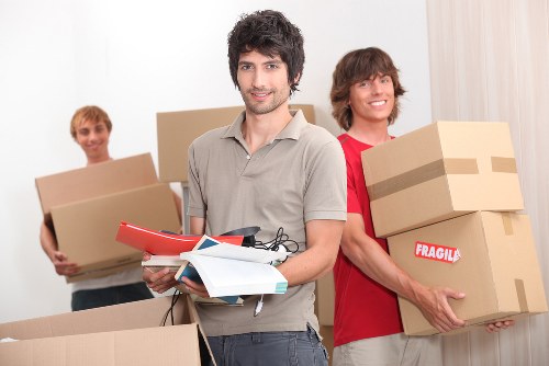 Packed moving boxes and furniture prepared for collection by a local van team